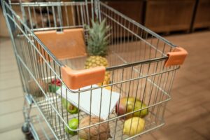 Trolley with fruit products in the supermarket .